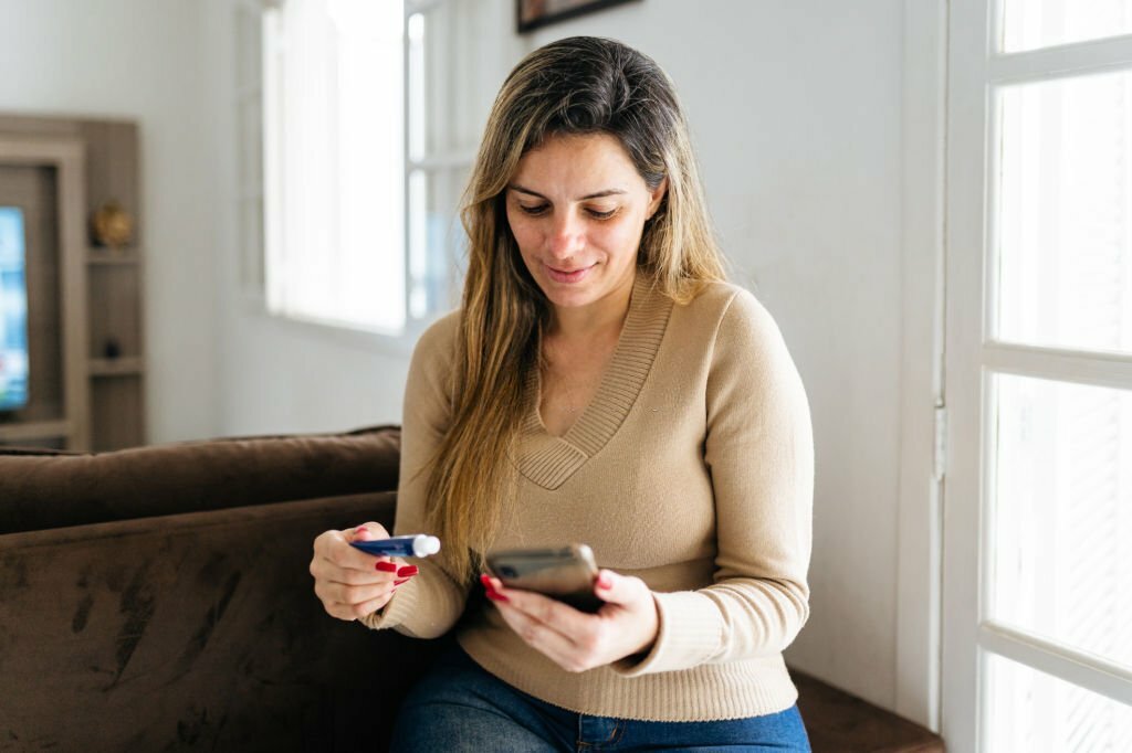 Woman checking ointment on smartphone Woman checking ointment on smartphone